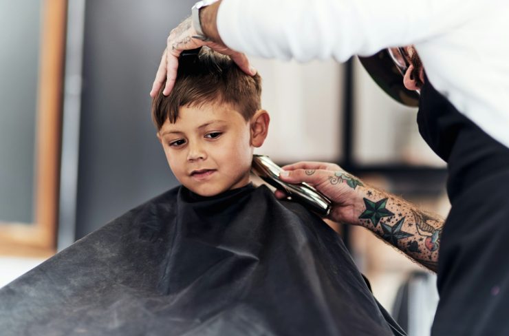 Cropped shot an adorable little boy getting a haircut at the barbershop